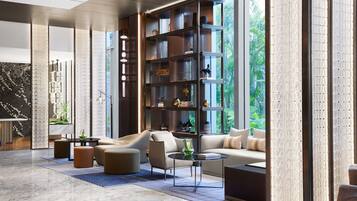 A modern living room with a large bookshelf, leather sofas, and a marble floor.
