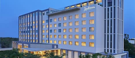 A Radisson hotel with a modern design, featuring a large number of uniformly lit windows and a prominent signage.