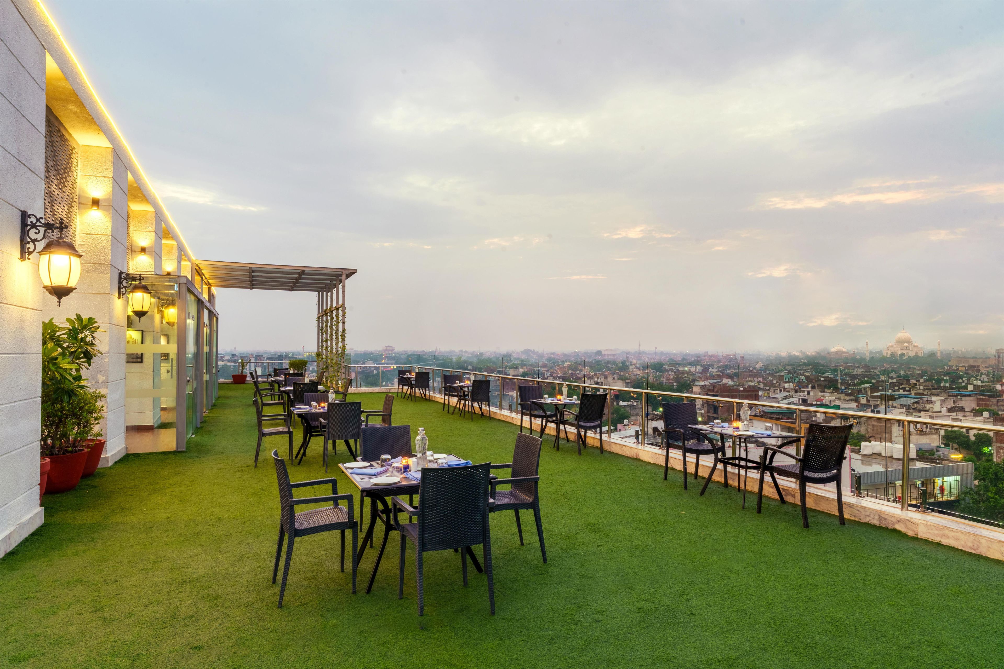 A rooftop terrace with outdoor seating, a pergola, and a city view.
