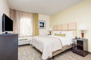 Escritorio, cortinas blackout y tabla de planchar con plancha