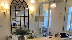 A reception area with a large white cabinet with multiple drawers, a mirror, and two wall-mounted lamps. - Sonnerupgaard Gods (Hvalso)