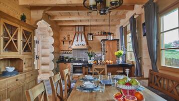 Cozy cabin with a dining area, kitchen, and large window offering a view of the surrounding landscape.