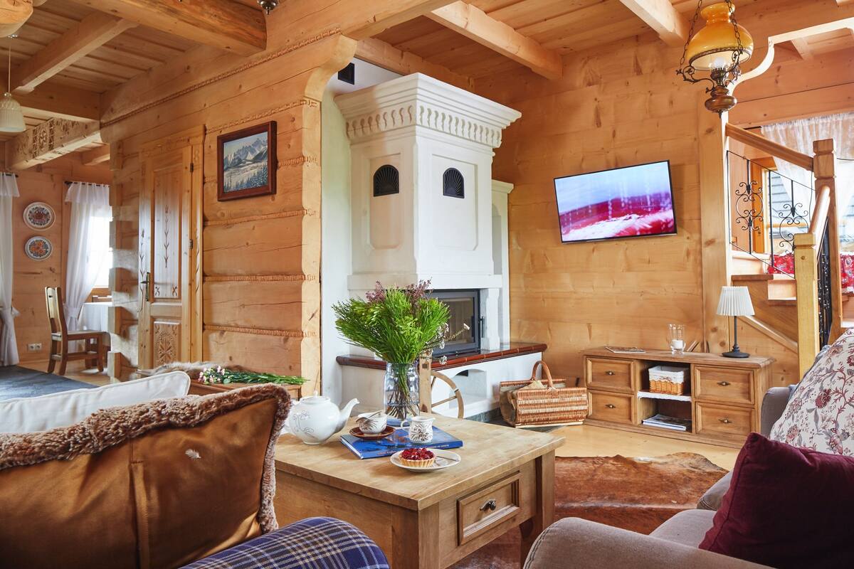 Un interior acogedor de madera con chimenea, televisor y zona de comedor.