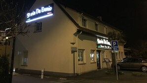 A building with a sign reading "Stella Da Ennio" and a parking sign indicating a 50-meter distance. - Storia Da Ennio (La Verriere)