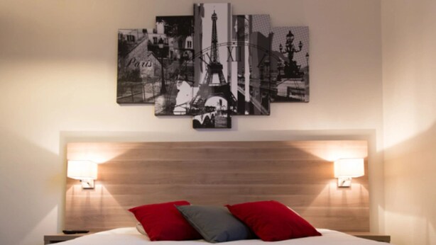 A bed with red and gray pillows, a wooden headboard, and two wall-mounted lamps. - Storia Da Ennio (La Verriere)
