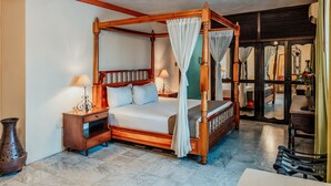 A four-poster bed with a canopy, a nightstand with a lamp, and a vase on the floor. - Casa del Balam Merida (Mérida)