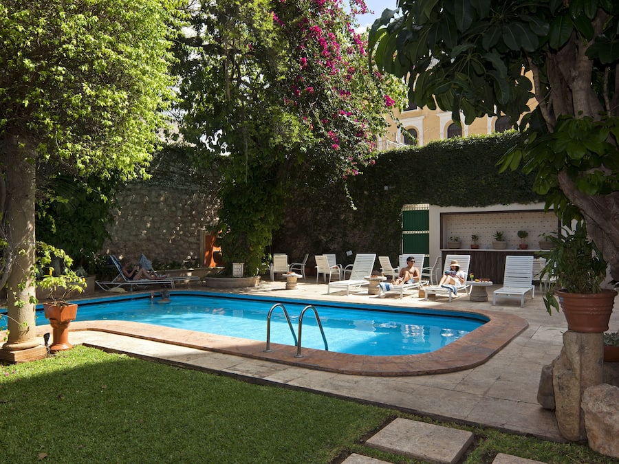Una piscina al aire libre, sillones reclinables de piscina