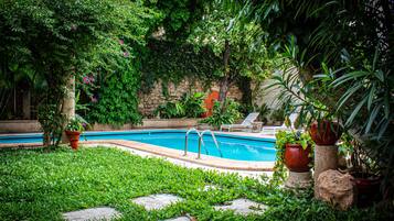 Alberca al aire libre y camastros