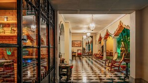 A hotel lobby with a checkered floor, ornate columns, and a glass door with a sign. - Casa del Balam Merida (Mérida)