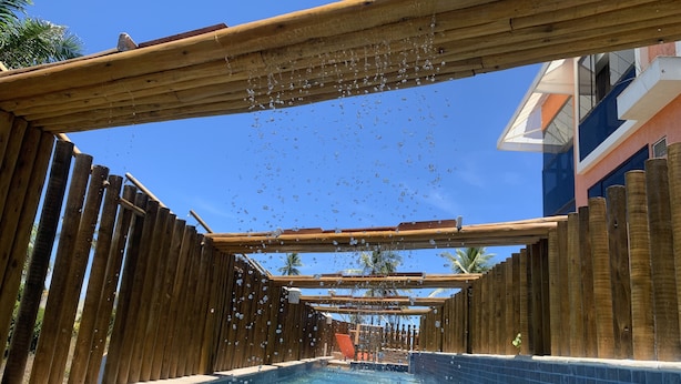 A wooden pool with a clear blue water surface and a wooden deck surrounding it. - Villaggio Orizzonte (Salvador)