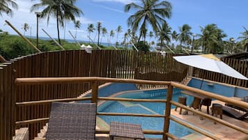 Relax by the ocean with a clear view, surrounded by palm trees and a pool.
