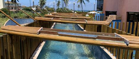 A pool area with wooden walkways and palm trees in the background.