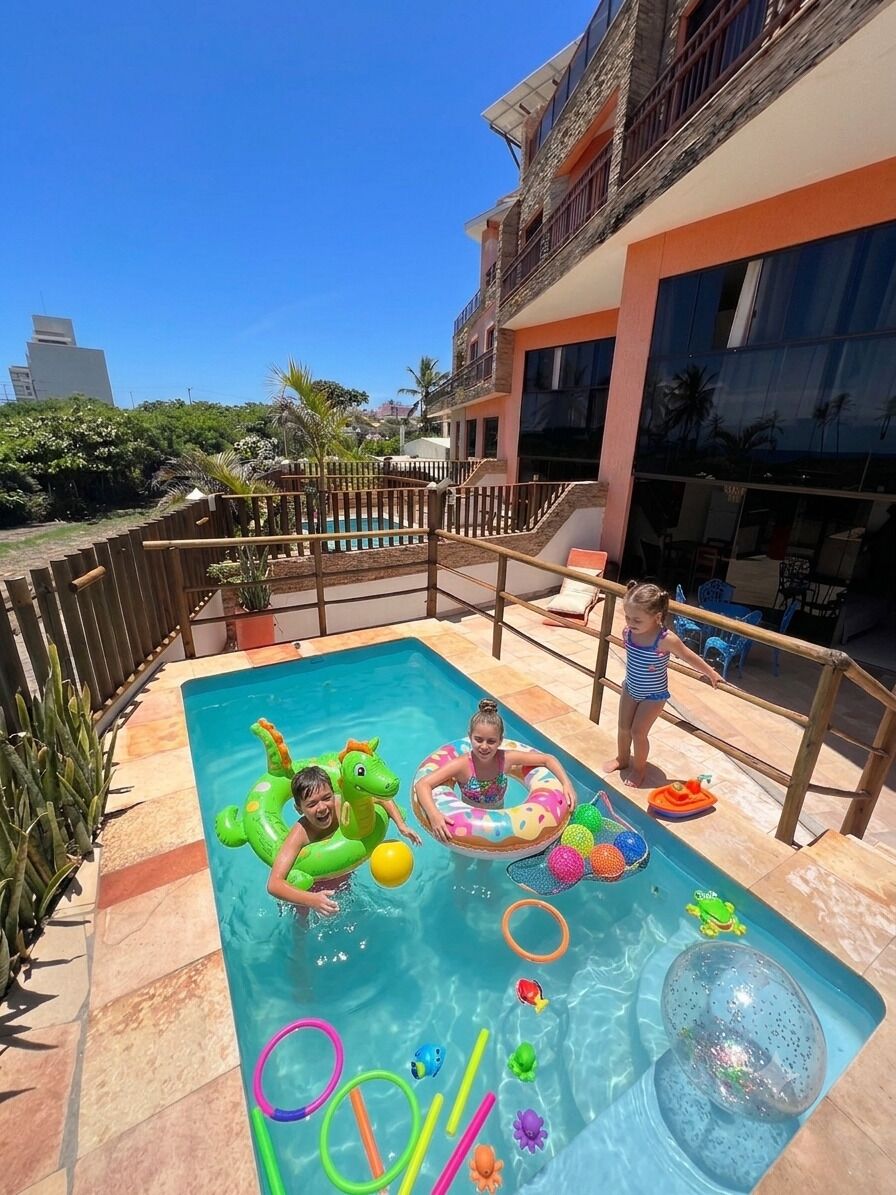 Piscina com brinquedos infláveis e uma criança perto da borda.