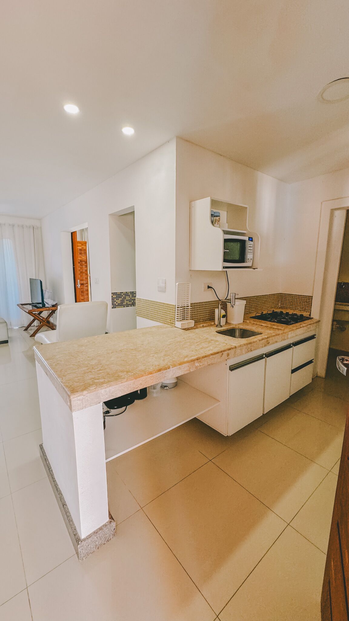 A modern kitchen with white cabinetry, a built-in microwave, and a gas stove.