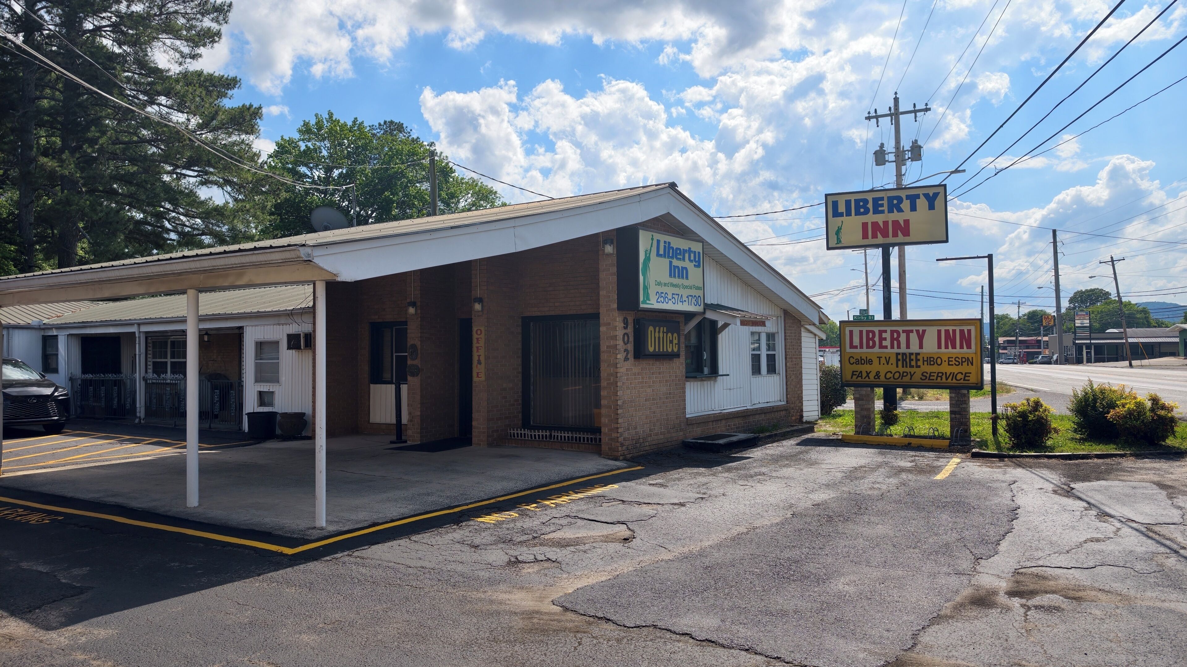 A Liberty Inn with a covered parking area, a brick building, and a signboard advertising cable TV, free HBO, ESPN, and fax & copy service.