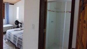 A room with a bed, a chair, and a door leading to another room. - Albergue Rio Vermelho - Hostel (Salvador)