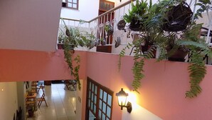 A multi-level interior with potted plants, a staircase, and a seating area. - Albergue Rio Vermelho - Hostel (Salvador)