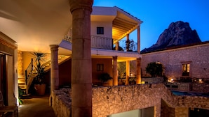 A multi-level building with stone columns, a balcony, and a mountain view. - Hotel Boutique Casa Mateo (Ezequiel Montes)