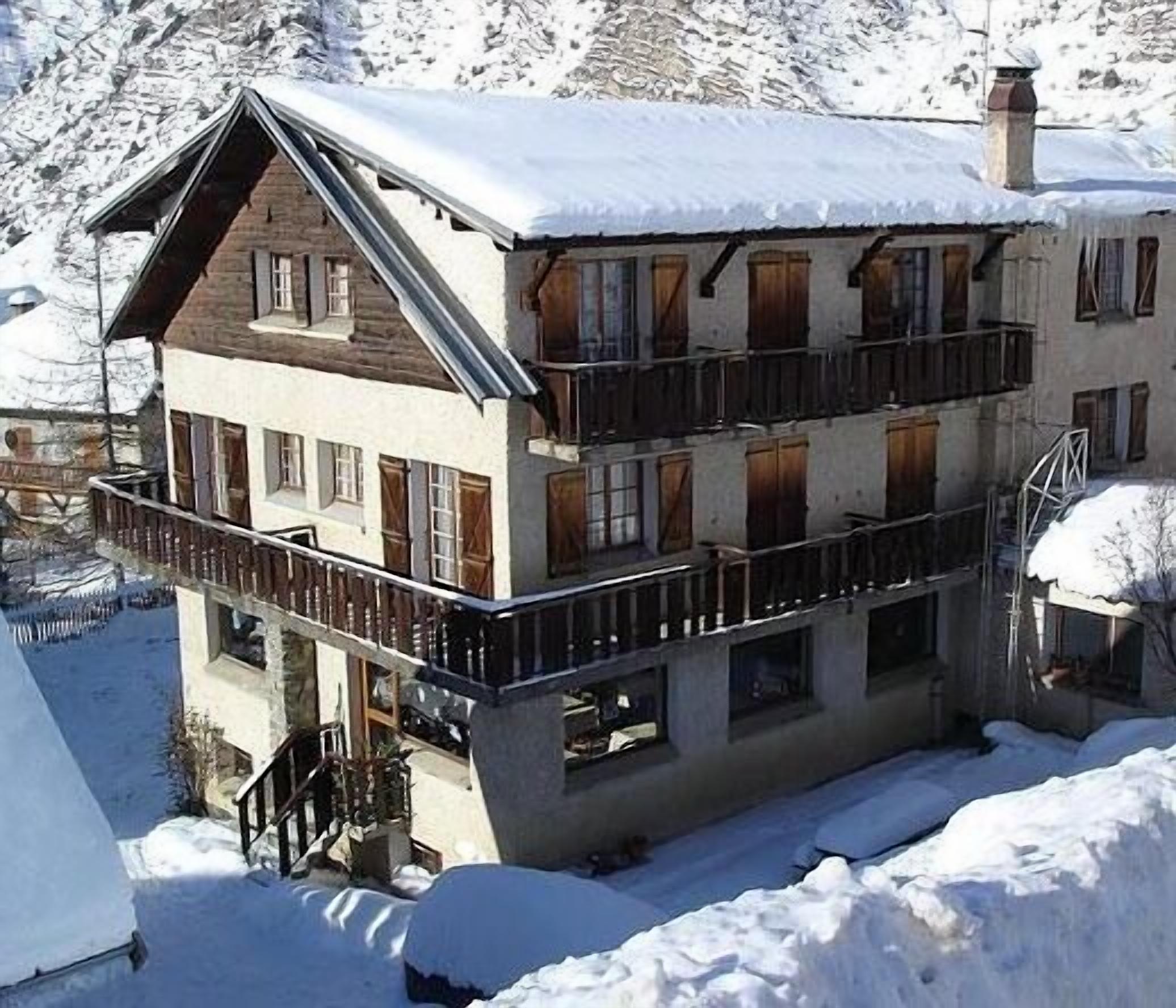 A multi-story building with balconies, surrounded by snow.