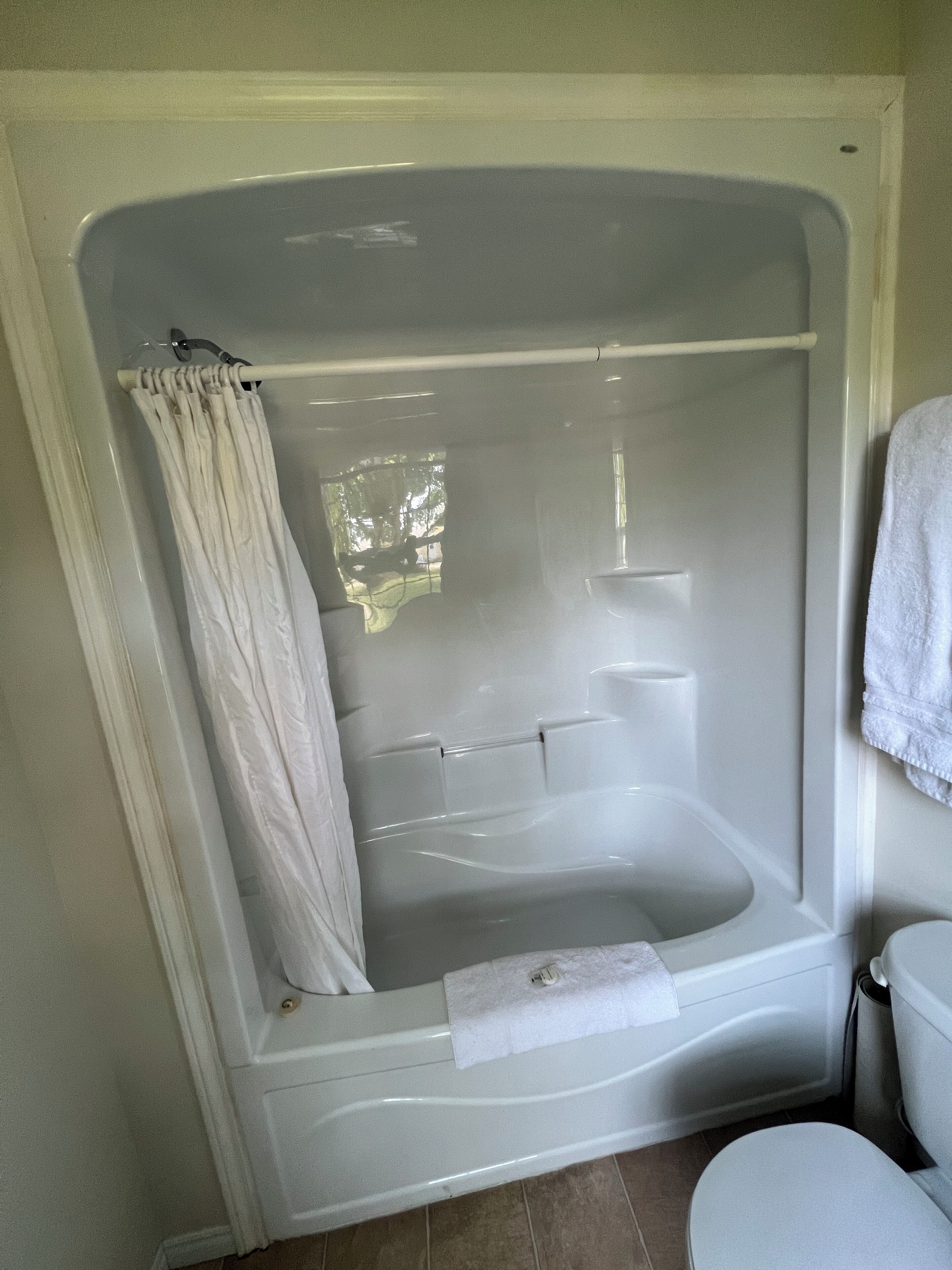 A bathroom with a bathtub, toilet, and a shower curtain.