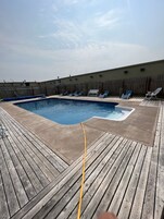 Una piscina al aire libre de temporada, sillones reclinables de piscina
