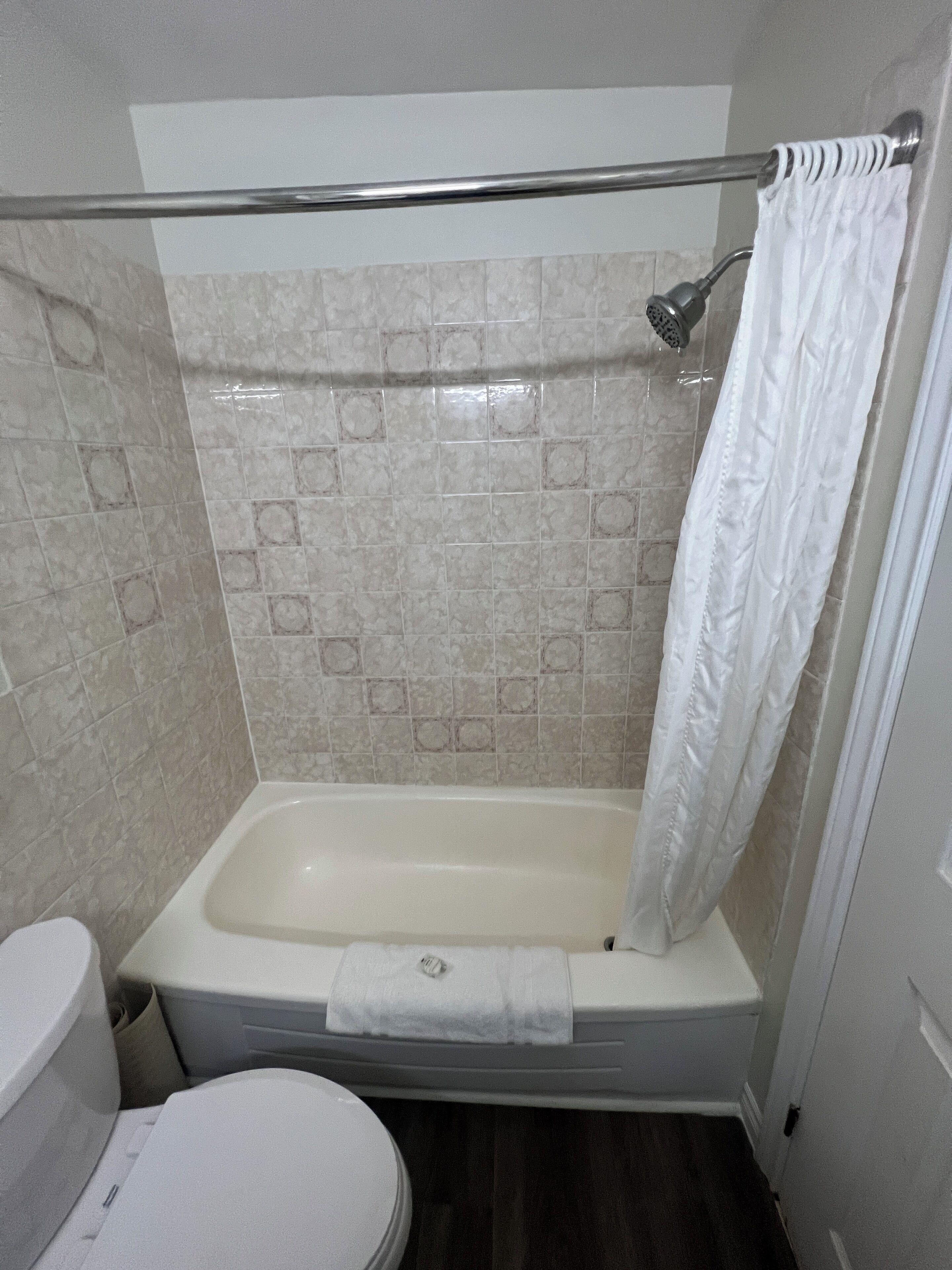 Un baño con bañera, inodoro y cortina de ducha.