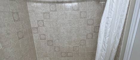 Un baño con bañera, inodoro y cortina de ducha.