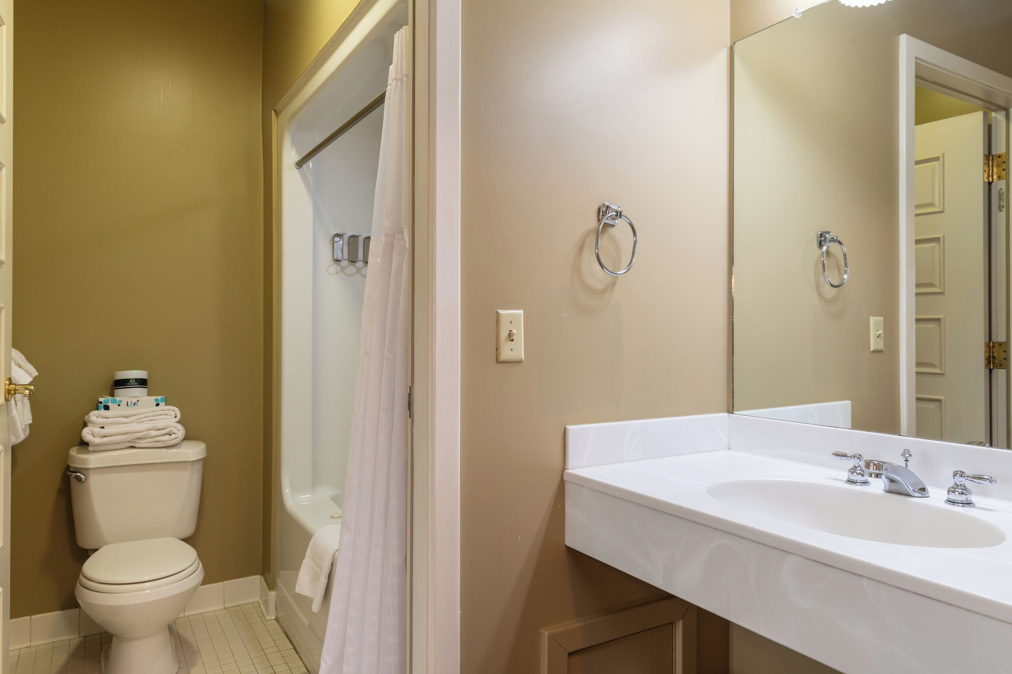 A bathroom with a white sink, a toilet, and a shower area.
