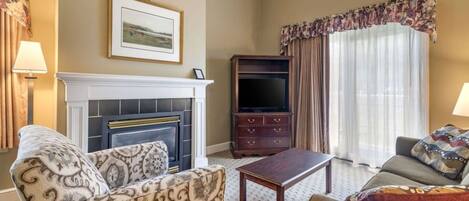A living room with a fireplace, a television, and a sofa.