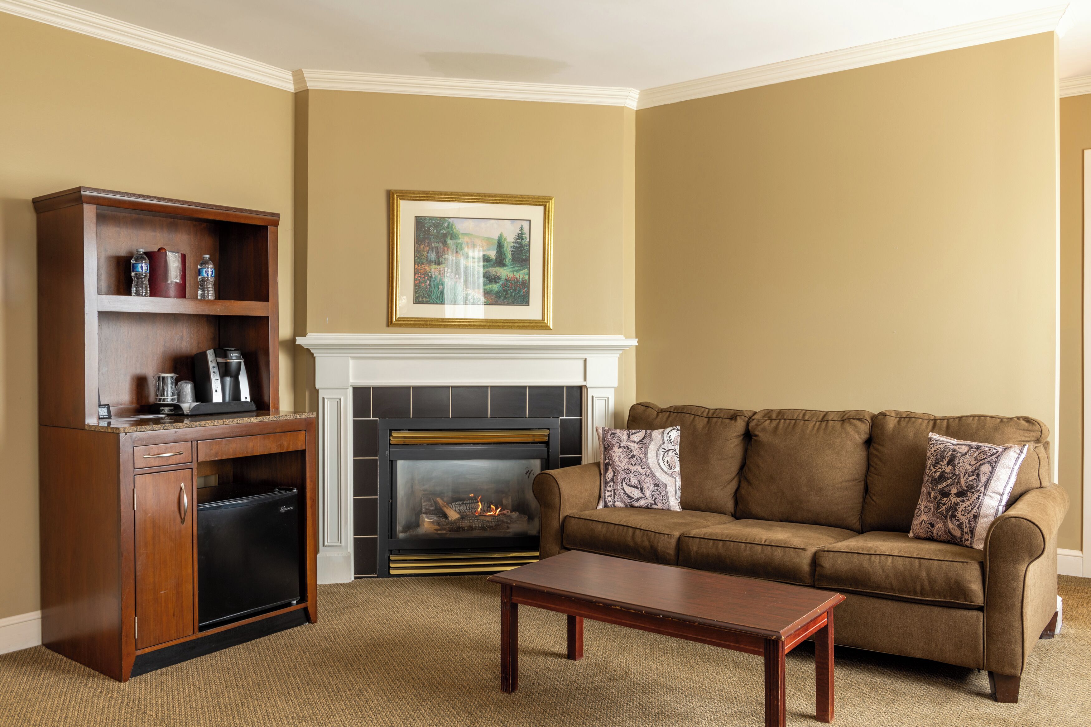 A living room with a fireplace, a sofa, a coffee table, and a wooden cabinet.