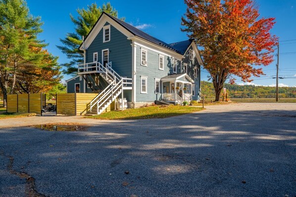 A two-story house with a front porch and a staircase leading to the upper level.