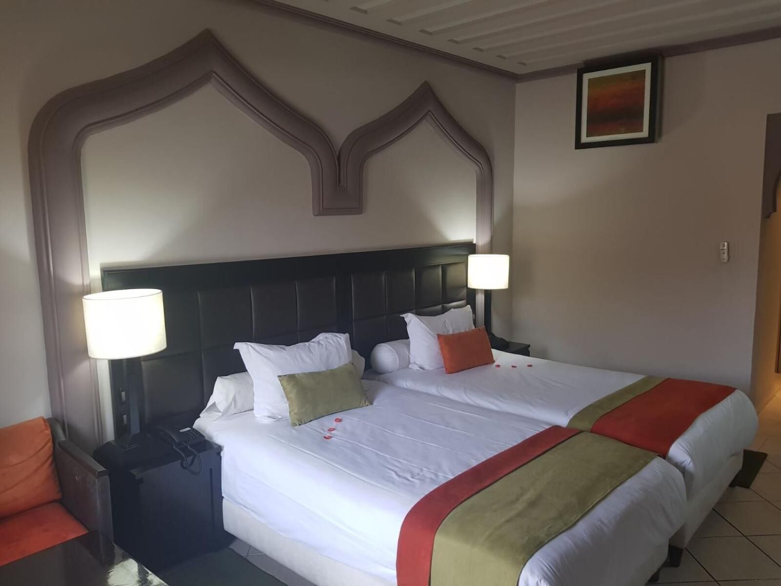 A hotel room with a large bed, two nightstands, a desk, and a chair.