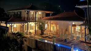 A two-story wooden house with a balcony, outdoor seating area, and a swimming pool. - Hôtel Le Résinier (Le Barp)