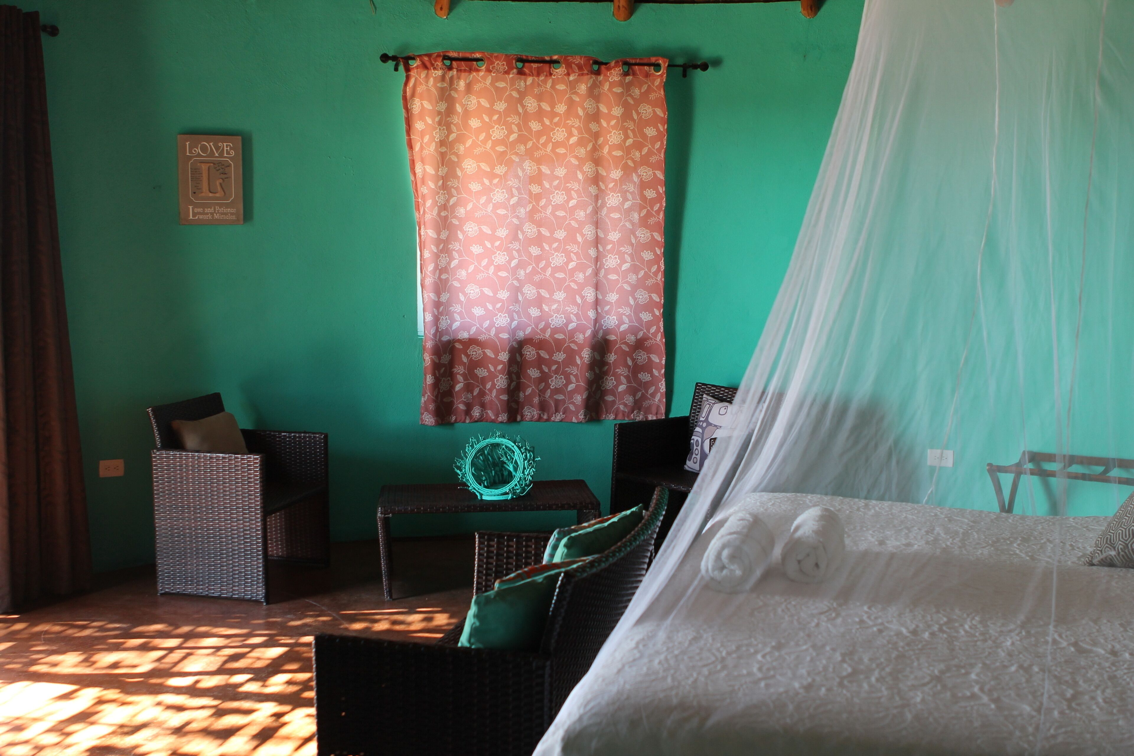 Une chambre à coucher comprenant un lit, une chaise, une petite table et un élément de décoration fixé au mur.