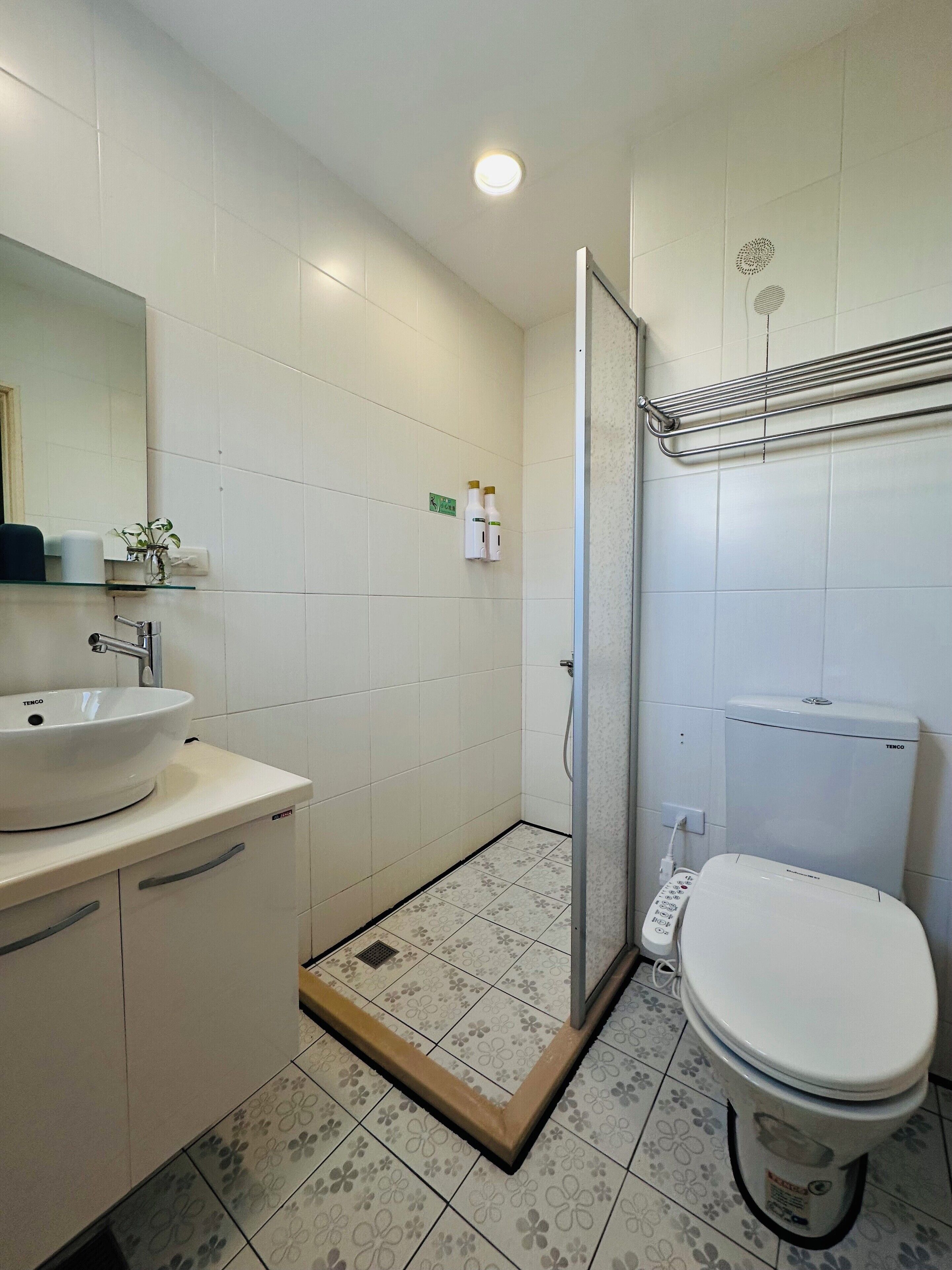 A bathroom with a sink, toilet, and shower area.