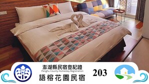 Una habitación de hotel con cama, una mesita y ventana con cortinas.