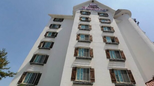 A multi-story hotel with a white facade, multiple balconies, and a sign indicating it is a hotel. - Hotel Ballantine (Cheonan)