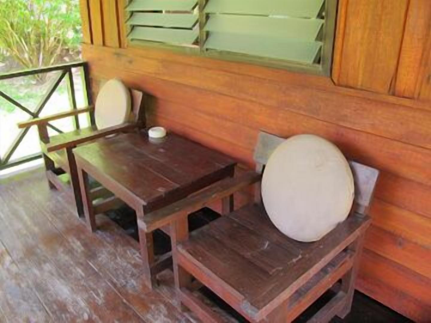 A wooden deck with a table and two chairs.