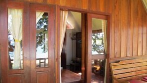 Una habitación de madera con un banco y una puerta que da a otra habitación.