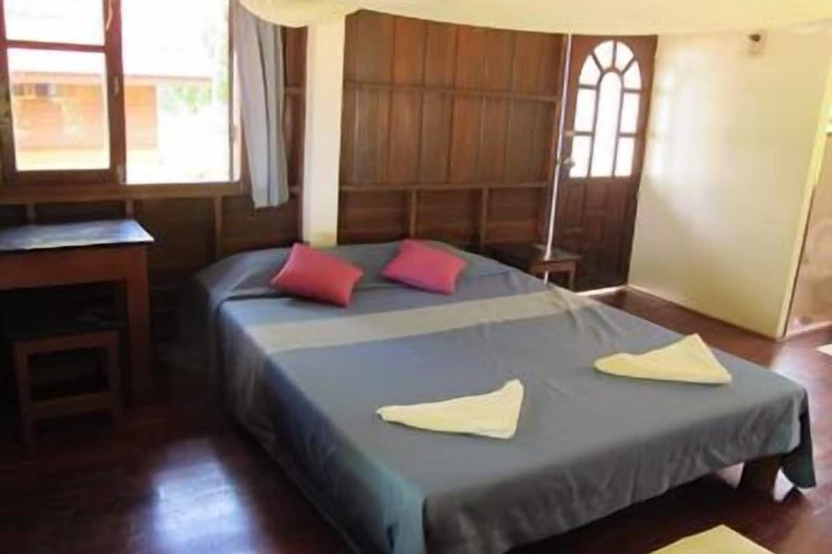 A room with a bed, a small table, and a window.