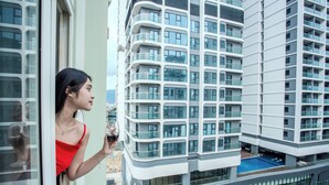 Un moderno edificio de gran altura con varios balcones y una piscina.