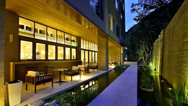 A modern hotel with a pool, outdoor seating, and a well-lit facade. - Chihpen Century Hotel (Taimali)