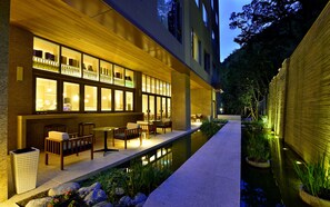 A modern hotel with a pool, outdoor seating, and a well-lit facade. - Chihpen Century Hotel (Taimali)