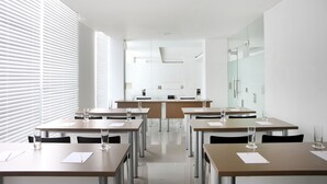 A modern conference room with tables, chairs, and glass partitions. - Amaris Hotel Malang (Malang)
