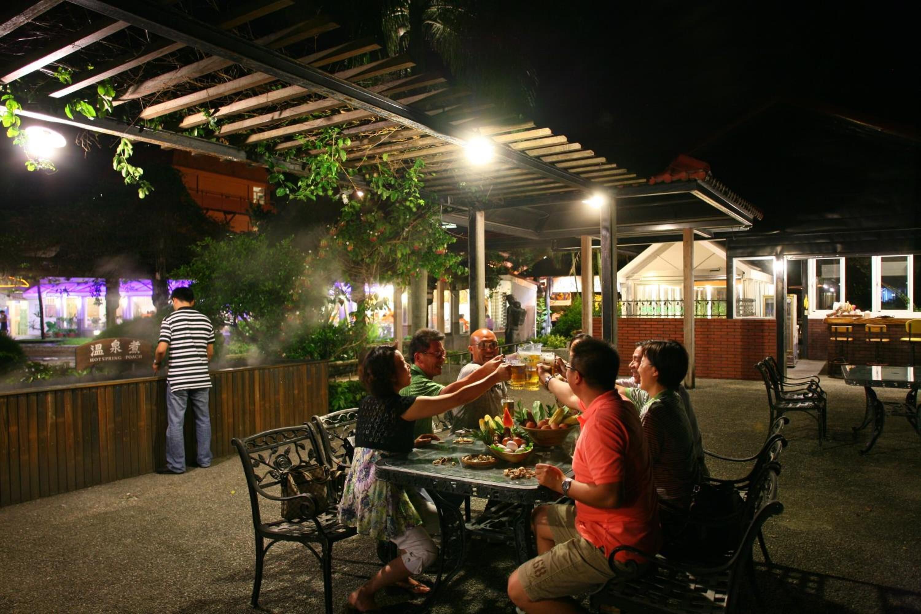 An outdoor dining area with a covered patio, tables, and chairs.