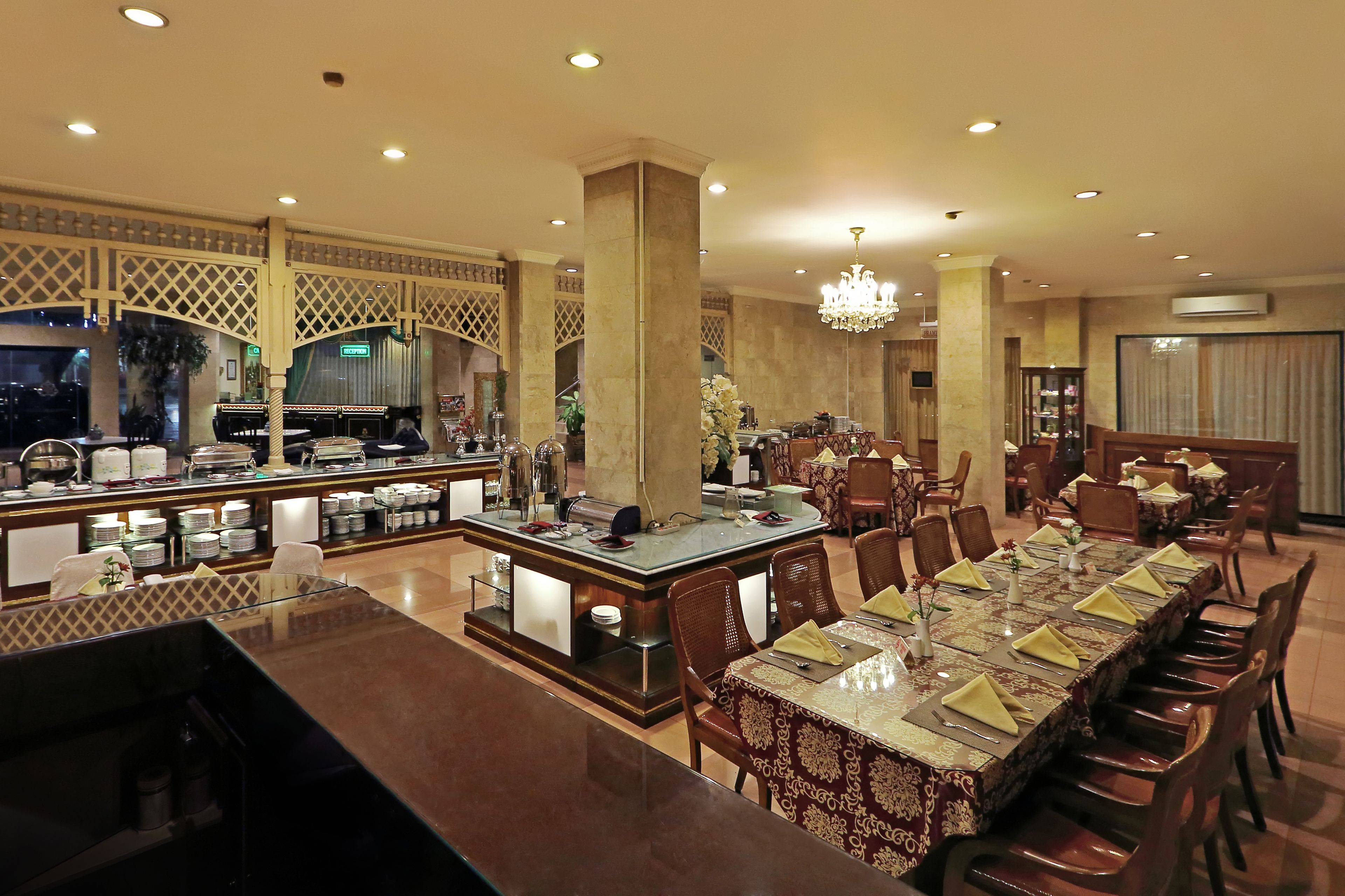 A spacious dining area with a long table set for a meal, surrounded by chairs.
