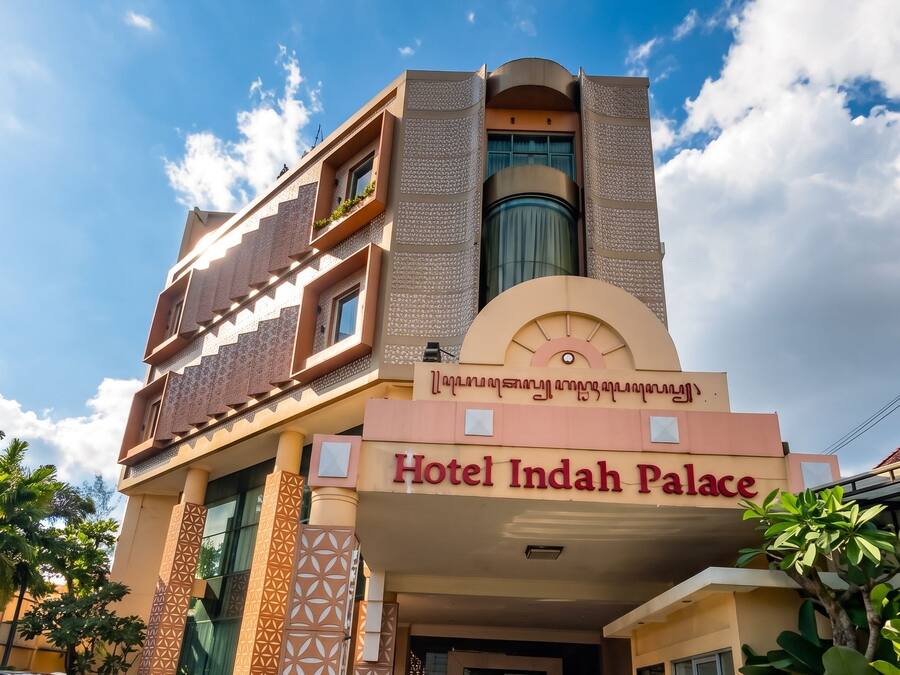 Ein Hotel mit moderner Architektur, das eine markante Eingangshalle und einen klaren Himmel zeigt.