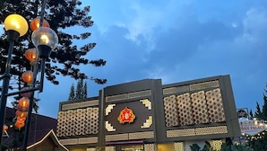 A modern building with a prominent logo, a well-lit entrance, and a paved area in front. - Hotel Indah Palace Tawangmangu (Tawangmangu)