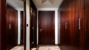 Un couloir avec des portes en bois et un sol en marbre.