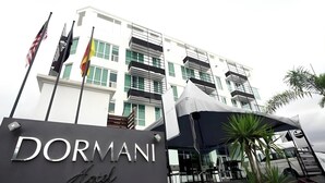 A hotel entrance with a sign reading 'DORMANI Hotel' and a modern building with balconies in the background. - Dormani Hotel Kuching (Kuching)